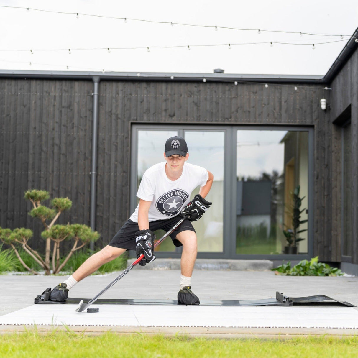 Ung hockeyspelare på en slide board tränar lateral rörelser för att förbättra balans och styrka. Perfekt för hockeyträning.