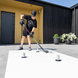 Young hockey player practicing shooting technique on a training surface with Extreme Drill Cones.