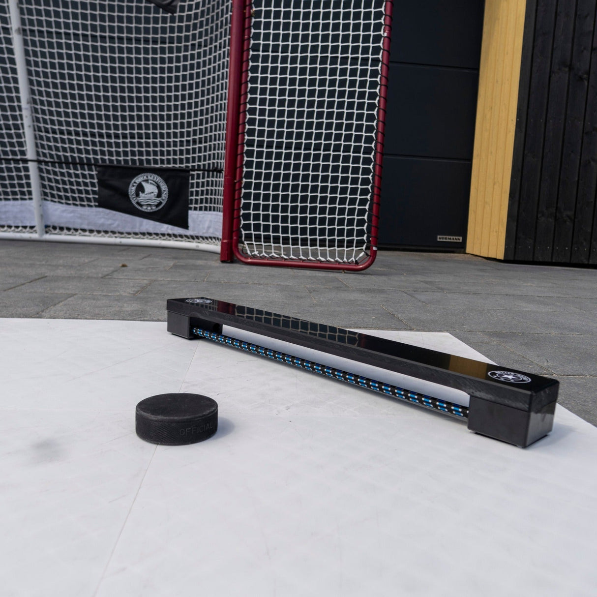 Hockeypassare Extreme Hockey Rebounder med puck på träningsyta, perfekt för passningsträning.