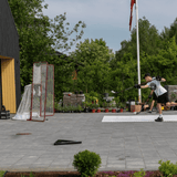 En spelare tränar med en skottmätare och hockey radar i trädgården, riktad mot ett mål.