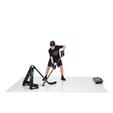 En ung spelare tränar på Extreme hockeygolv med en hockeyklubba och utrustning, vilket simulerar isupplevelsen.