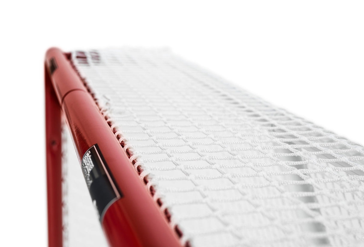 Närbild av det röda ramsystemet och nätet på ett hockeymål, perfekt för träning hemma.